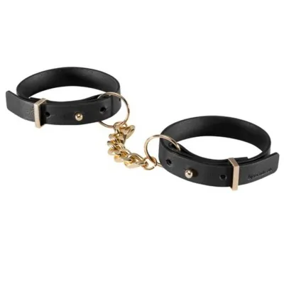 Schwarze Lederhandschellen mit goldener Kette verbunden.