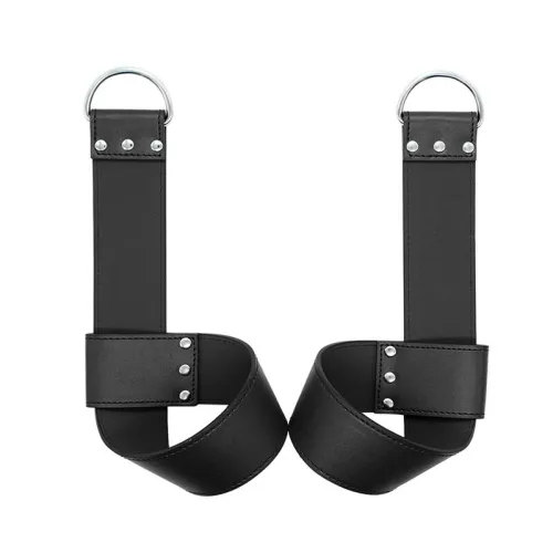 Two black leather restraints with silver D-rings and rivets on a white background.