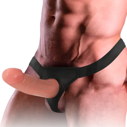 Ein Mann trägt einen schwarzen Jockstrap mit einem großen, realistisch aussehenden Dildo.