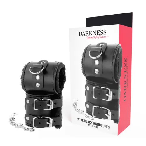 Schwarze, breite Handschellen mit Fell und Kette, neben einer Verpackung mit der Aufschrift "Darkness".