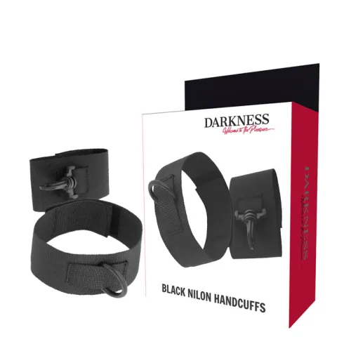Black nylon handcuffs in front of a package labeled "Darkness - Welcome to the Pleasure".