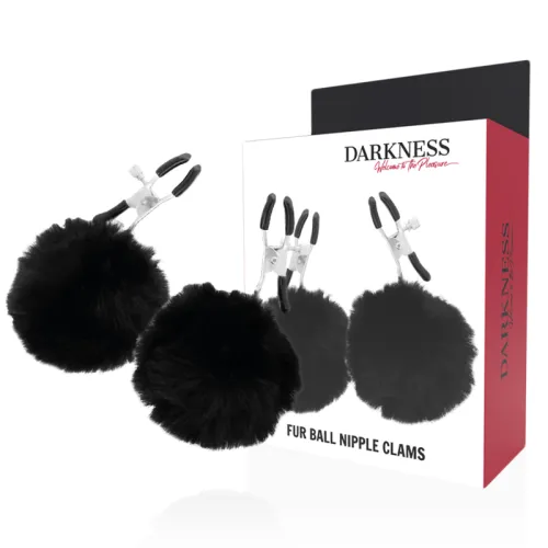 Black nipple clamps with fur balls, packaging with product image in the background.