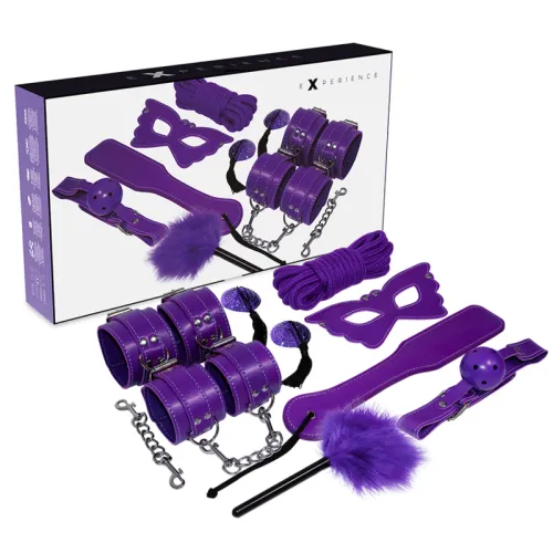 Lila Bondage-Set mit Augenmaske, Fesseln, Seil, Ballknebel und Federkitzler vor Verpackung.