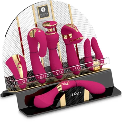 Various pink and gold massage devices on a black stand with a mesh back, brand name "Shunga" visible.