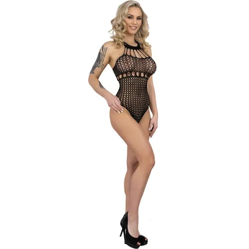Woman in black mesh bodysuit and high heels, smiling, with curly hair and a tattoo on her arm.