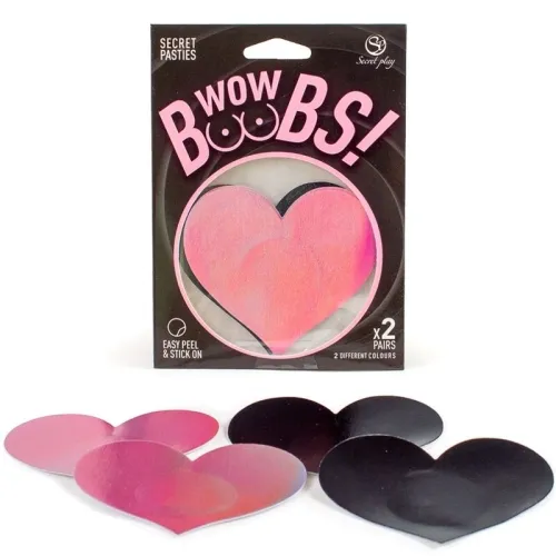 Herzförmige Brustaufkleber in Pink und Schwarz, Verpackung mit der Aufschrift "Wow Boobs!" im Hintergrund.