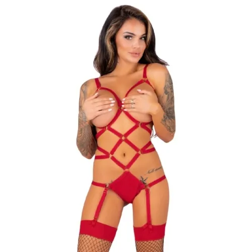 Woman in red lingerie with garter belt and fishnet stockings, tattooed arms, holds her hands in front of her chest.