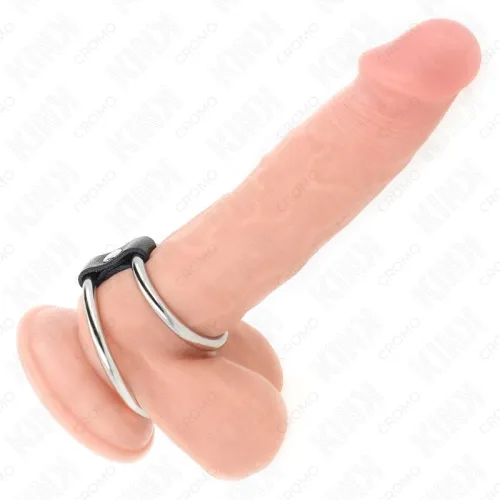 Ein Dildo mit zwei Metallringen und einer Saugnapfbasis auf weißem Hintergrund.