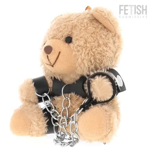 Plush bear with leather restraints and chains, sitting upright.