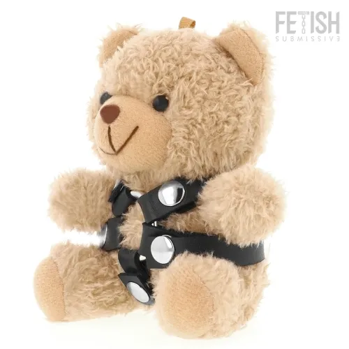 Plush bear with black leather harness and silver studs, sitting upright against a white background.