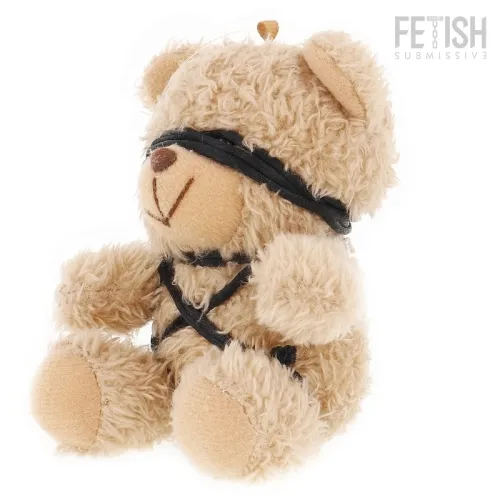 Plush bear with black band around its eyes and body, sitting upright.