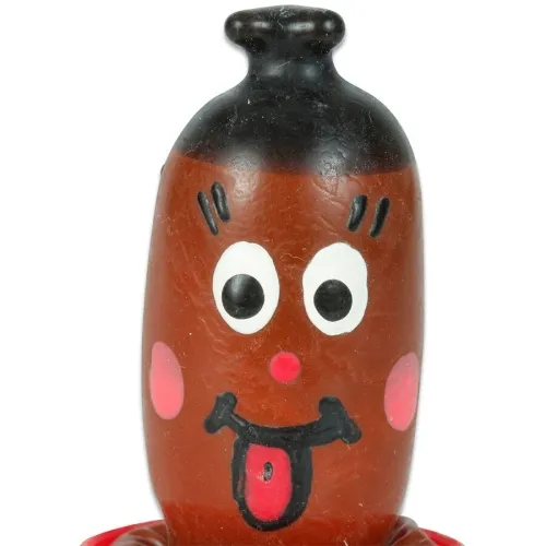Spielzeugfigur mit lachendem Gesicht, großen Augen und herausgestreckter Zunge.