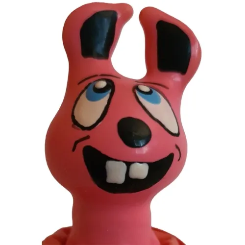 Rosa Cartoon-Hase mit großen Zähnen und blauen Augen, lächelt mit schiefem Blick.