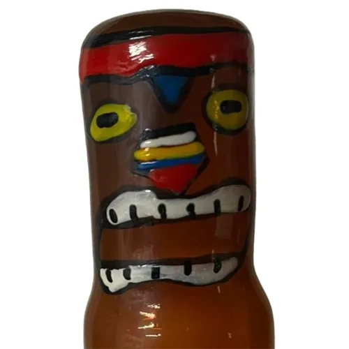 Bottle with a colorful, tribal face, red and yellow details, wide mouth and large eyes.