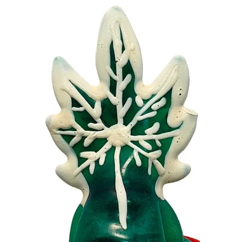 Grünes Blatt mit weißem Schneeflockenmuster aus Zuckerguss verziert.