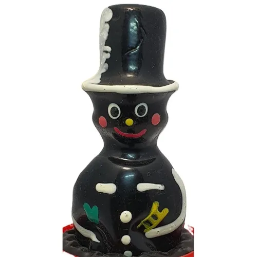 Chocolate figure of a chimney sweep with top hat, colorful details and smiling face.