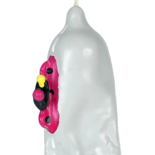 Grey candle with a red and black ladybug design on the side.