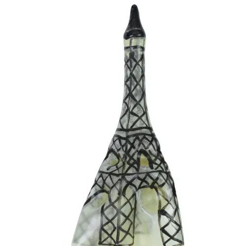Glasflasche in Form des Eiffelturms mit schwarzem Gittermuster auf weißem Hintergrund.