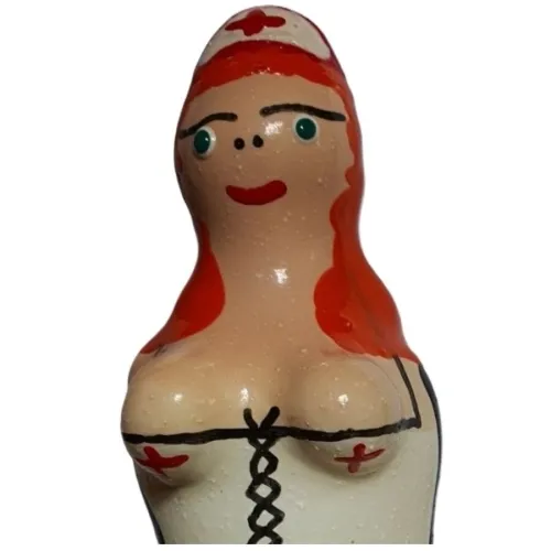 Ceramic figure of a nurse with red hair and cross symbols on her clothing.