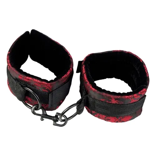 Black and red handcuffs with buckles and hooks, on a white background.