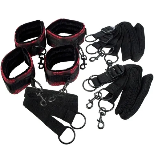 Black and red handcuffs and leg irons with buckles and straps on a white background.