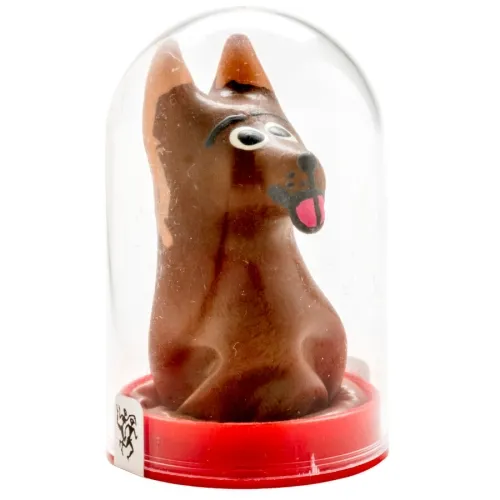 Schokoladenfigur in Form eines Hundes mit großen Augen und herausgestreckter Zunge, in einer durchsichtigen Kuppel.