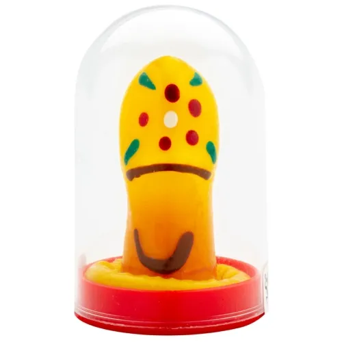 Yellow marzipan pastry in the shape of a mushroom with colorful dots, under a transparent dome on a red base.