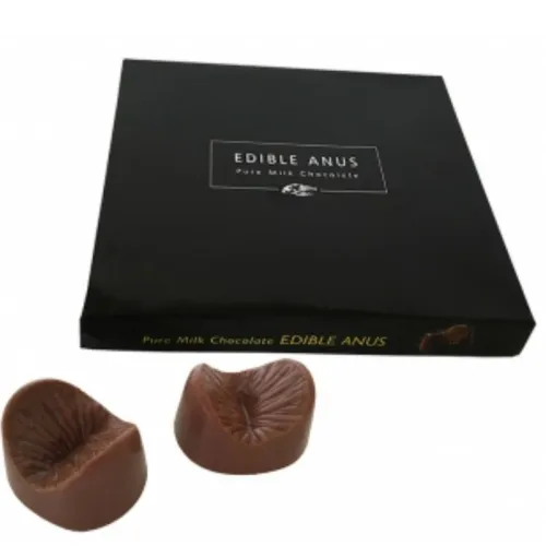 A box labeled "Edible Anus" with two chocolate-shaped anus-shaped pralines in front of it.