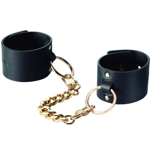 Black leather restraints with a gold chain and rings.