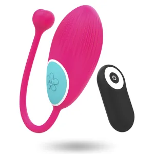 Rosa Vibrator mit Fernbedienung, blauer Knopf und Herzdetail, schwebend vor weißem Hintergrund.