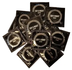 Mehrere schwarze Kondomverpackungen mit der Aufschrift "Day & Night" in einem Stapel angeordnet.