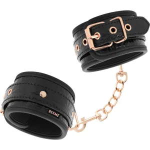 Schwarze Handfesseln mit goldenen Schnallen und Kette, stilvoll und modern gestaltet.