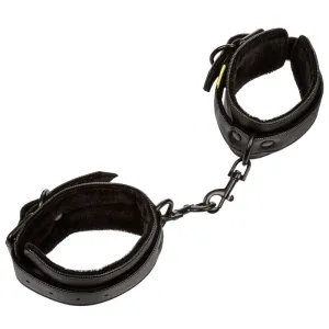 Schwarze, gepolsterte Handfesseln aus Kunstleder, verbunden durch eine kurze Kette mit Karabinerhaken.