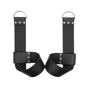 Two black leather restraints with silver D-rings and rivets on a white background.