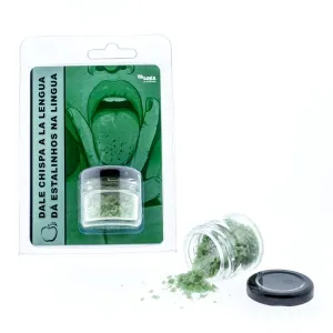 Grünes Knisterpulver in einem Glas, daneben Verpackung mit gezeichneter Zunge und Text auf Spanisch und Portugiesisch.