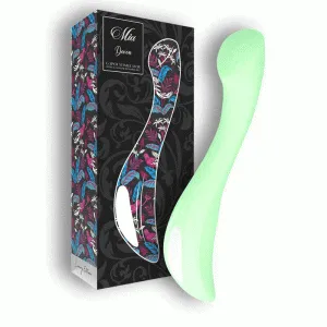 Grüner G-Punkt-Stimulator neben einer dekorativen Verpackung mit floralem Muster.