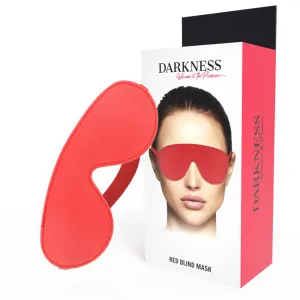 Rote Augenmaske neben Verpackung mit Bild einer Person, die die Maske trägt. Text: 