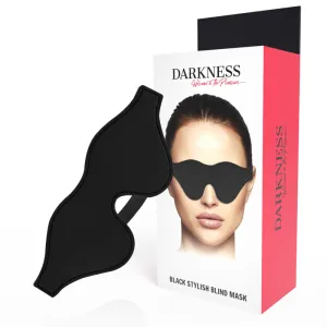 Schwarze Augenmaske vor Verpackung mit Bild einer Frau, die die Maske trägt. Text: 