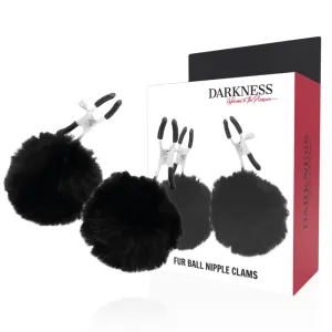 Schwarze Nippelklemmen mit Fellbällen, Verpackung mit Produktabbildung im Hintergrund.