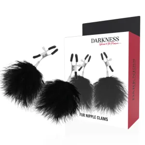 Schwarze Nippelklemmen mit Fell, Verpackung mit Produktabbildung im Hintergrund.