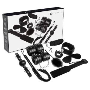 Schwarzes Bondage-Set mit Fesseln, Augenbinde, Ballknebel, Peitsche und weiteren Accessoires vor Verpackung.