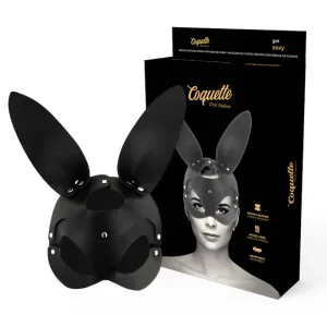 Schwarze Hasenmaske aus veganem Leder vor Verpackung mit Abbildung einer Person, die die Maske trägt.