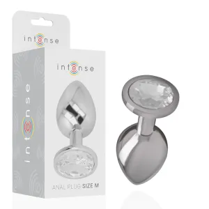 Silver anal plug with crystal, size M, next to packaging with 