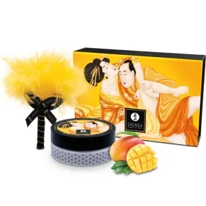 Shunga-Set mit gelbem Federkitzler, Dose und Verpackung mit Kunstmotiv, daneben eine Mango.