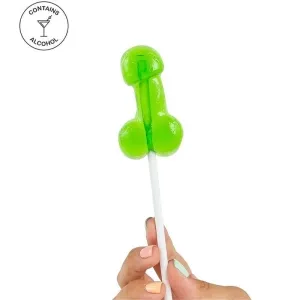Grüner Lutscher in Form eines Penis, enthält Alkohol, wird von Hand mit bunten Nägeln gehalten.