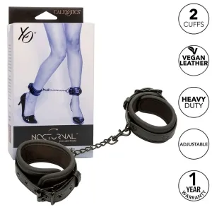 Schwarze Fußfesseln aus veganem Leder, verstellbar, mit Kette, Verpackung zeigt Beine in High Heels, 1 Jahr Garantie.