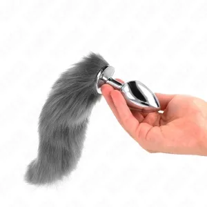 Hand holding a silver plug with a grey, fluffy tail.
