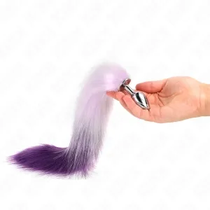 Hand holding a silver plug with a purple and white faux fur tail against a white background.
