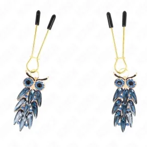 Zwei Eulen-Ohrringe mit blauen Kristallen und goldenen Details, an goldenen Haken mit schwarzen Enden.