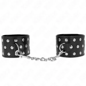 Black leather handcuffs connected with silver rivets and chain.